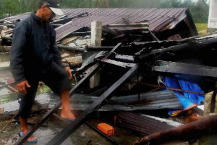 Homem caminha entre os destroços de sua casa, destruída pelo tufão Nari: tufão já havia provocado 13 mortes no fim de semana (AFP)