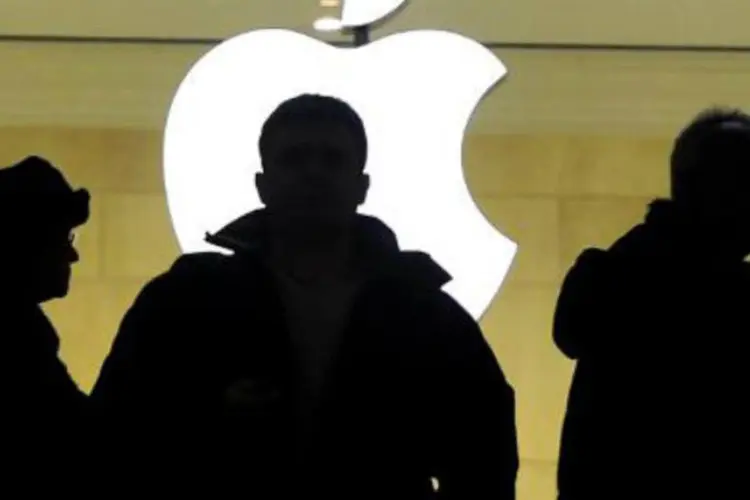 
	Pessoas caminham em frente &agrave; loja da Apple: vendas de iPhones totalizaram 51,0 milh&otilde;es de unidades no primeiro trimestre fiscal de 2014
 (Timothy A. Clary/AFP)