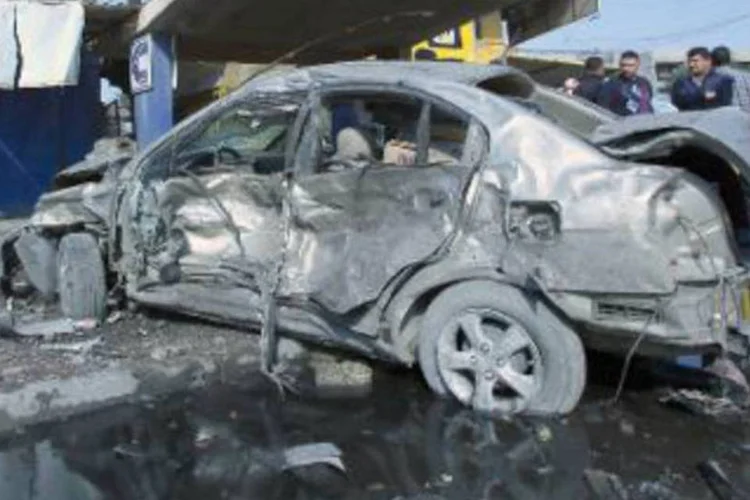 Policial iraquiano observa o cenário de um atentado terrorista, no centro de Bagdá: 24 pessoas morreram na explosão de ao menos sete carros-bomba (Ali al-Saadi/AFP)