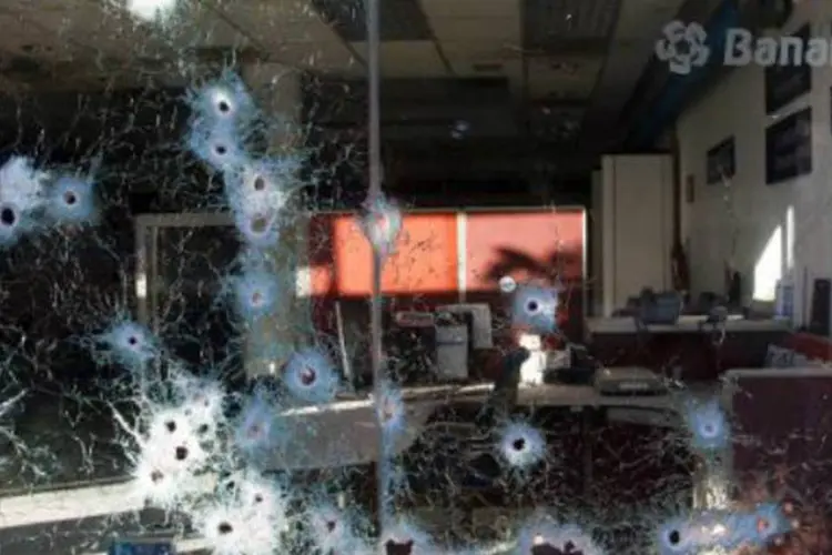 Vitrine de banco alvejada por balas, no México: civis armados fazem ofensiva contra o cartel Os Cavaleiros Templários (Hector Guerrero/AFP)