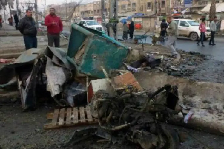Civis observam destroços de uma explosão no Iraque: atentados não foram reivindicados (Ahmad Al-Rubaye/AFP)