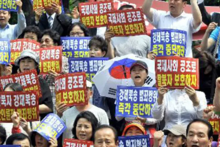 
	Ativistas sul-coreanos protestam contra a repatria&ccedil;&atilde;o for&ccedil;ada de 9 norte-coreanos: h&aacute; cinco anos, 3.000 norte-coreanos chegavam por ano &agrave; Coreia do Sul
 (Jung Yeon-Je/AFP)