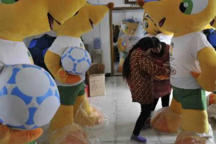 Trabalhadores ajustam um boneco do Fuleco: Tongchuang Toys já enviou 500.000 exemplares destes bonecos no mês passado ao Brasil (AFP)