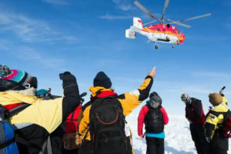 Helicóptero do quebra-gelos chinês Xue Long: navio russo permanece preso no gelo (Andrew Peacock/AFP)