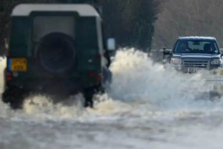 Carros enfrentam as cheias na Inglaterra: graves inundações causadas pelas fortes chuvas afetam o país há dias (Ben Stansall/AFP)