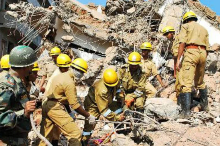 Membros do resgate procuram por vítimas nos destroços: possibilidades de encontrar sobreviventes são muito pequenas (AFP)