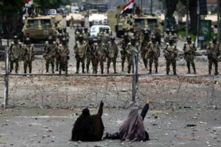 
	Manifestantes partid&aacute;rias de Mursi desafiam militares: tumultos se espalharam por &aacute;reas densamente povoadas em v&aacute;rias cidades e prov&iacute;ncias do Egito
 (Mahmud Hams/AFP)