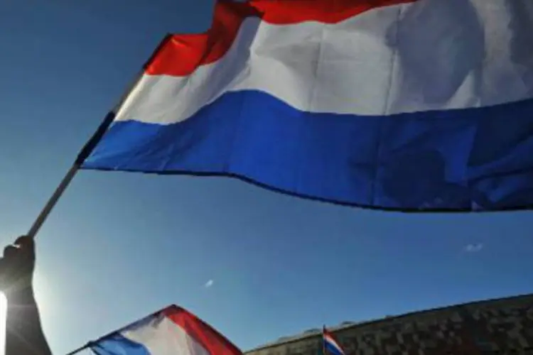 
	Bandeira da Holanda: jovens em Veen tradicionalmente ateiam fogo a destro&ccedil;os de carros na noite do Ano Novo
 (Monirul Bhuiyan/AFP)