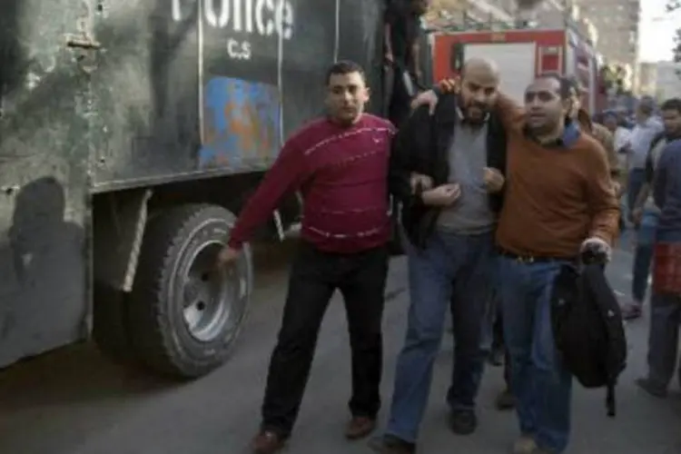 Policiais egípcios prendem simpatizante da Irmandade Muçulmana: confrontos ocorrem após o governo egípcio declarar a Irmandade uma organização terrorista (Khaled Desouki/AFP)