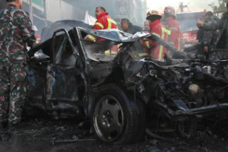 Forças de segurança ao redor de carro destruído em atentado: Líbano foi fortemente afetado pelo conflito na vizinha Síria (AFP)