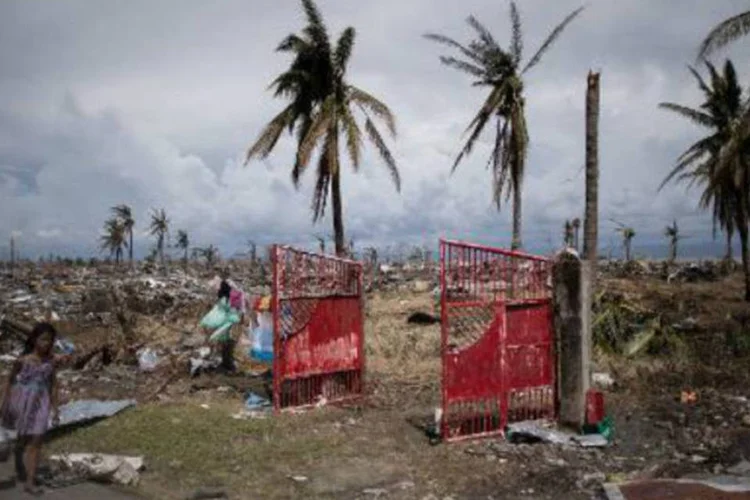 
	V&iacute;tima do tuf&atilde;o Haiyan caminha pela regi&atilde;o destru&iacute;da de Tacloban: milhares de moradores ter&atilde;o que reconstruir sua vida do zero depois de perder fam&iacute;lia, casa e pertences
 (Philippe Lopez/AFP)