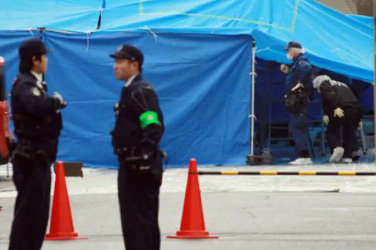 Policiais em local de crime no Japão: o cadáver apresentava três marcas de bala (AFP)