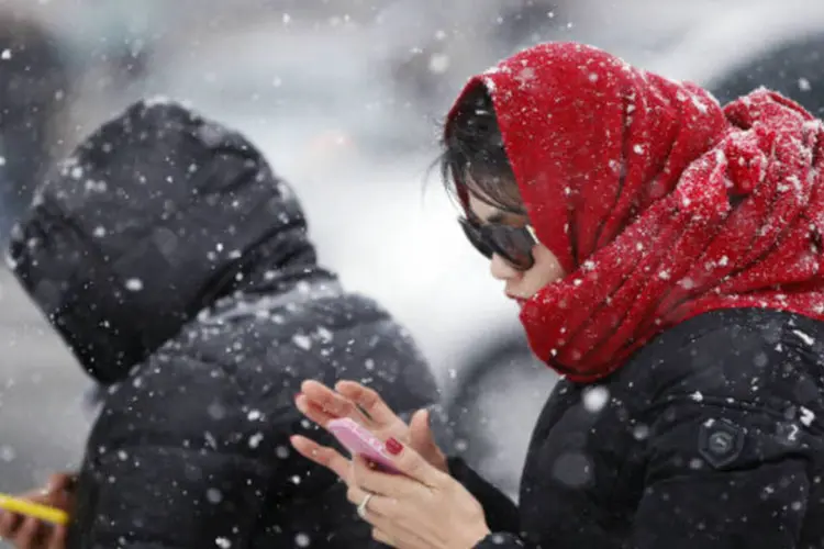 Mulheres com celular até durante nevasca: "ela caiu de costas na água, e ficou boiando. Ainda tinha o celular na mão", disse policial (Kim Hong-Ji/Reuters)