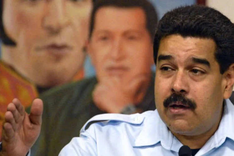 Nicolás Maduro, com pintura de Hugo Chávez e Simón Bolívar ao fundo: Maduro também prestará homenagens (AFP/Getty Images)
