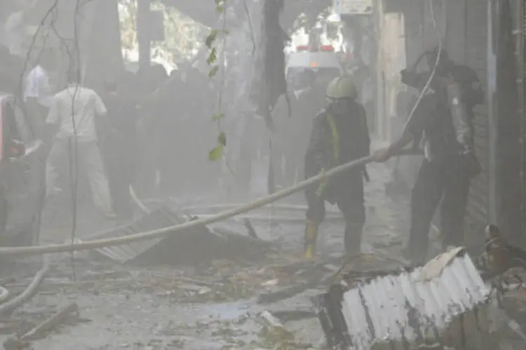Bombeiros trabalham em local de atentado em Damasco: fonte acusou supostos "terroristas" de lançar bombas (Sana/Handout via Reuters)