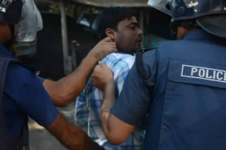 
	Policiais prendem manifestante em Bangladesh:&nbsp;confrontos come&ccedil;aram quando as for&ccedil;as da ordem tentaram prender v&aacute;rios acusados de provocar viol&ecirc;ncia
 (Getty Images)