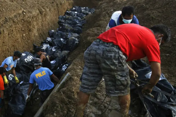 
	Corpos de v&iacute;timas do tuf&atilde;o Haiyan s&atilde;o enterrados: n&uacute;mero de mortes confirmadas chegou a 6.009, enquanto 1.779 pessoas continuam desaparecidas
 (Edgar Su/Reuters)