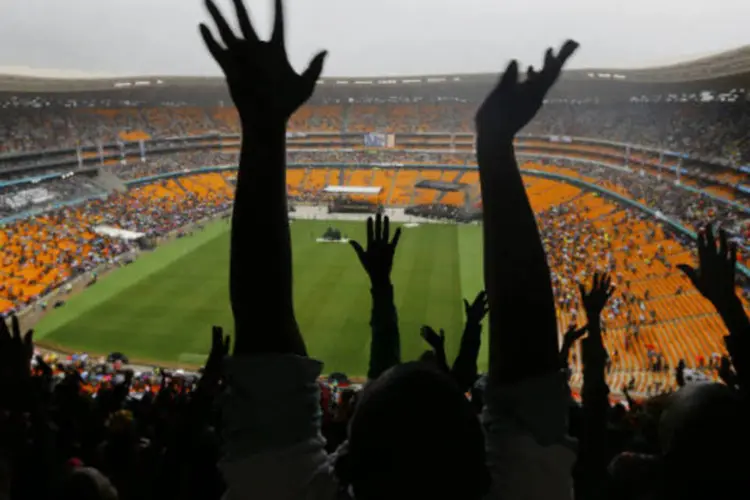 
	Pessoas homenageiam Mandela: &quot;ser&aacute; uma oportunidade para que torcedores e amantes do esporte das multid&otilde;es se unam e passem adiante uma mensagem de esperan&ccedil;a e amor em todo o mundo&quot;,&nbsp;disse a Fifa
 (Yannis Behrakis/Reuters)