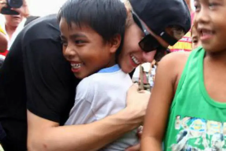 Astro do pop Justin Bieber abraça um menino: cantor canadense se dirigiu a Tacloban, uma das cidades mais atingidas pela tempestade (AFP)