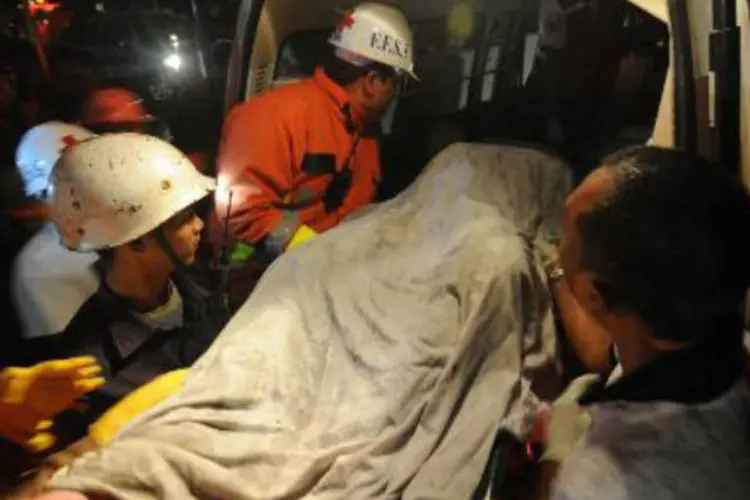 Corpo é resgatado após um incêndio em Yangun, em Mianmar: vítimas eram funcionários dos grandes depósitos Gandamar (Soe Than Win/AFP)