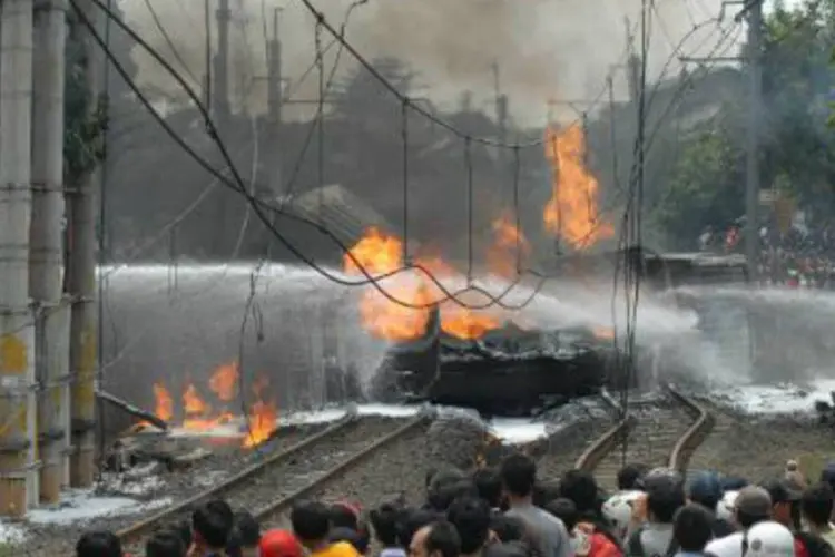 Pessoas observam o local do acidente entre um trem e um caminhão-tanque  na Indonésia: empresa informou que 600 passageiros estavam no trem (Bima Sakti/AFP)