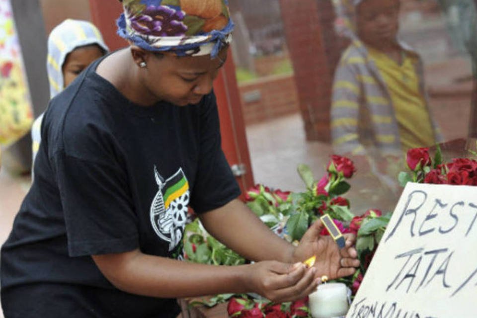 Velas e rosas são colocadas em homenagem a Mandela