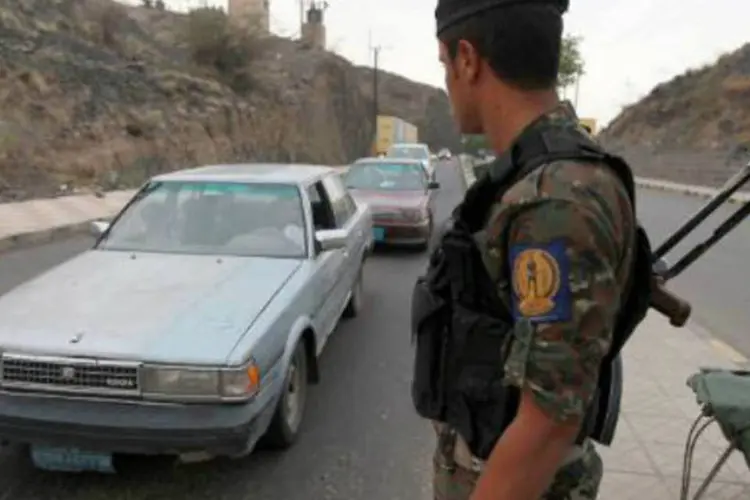 
	Soldado em um posto de controle na capital do I&ecirc;men, Sana: entre os mortos est&atilde;o sete dos criminosos, que entraram no complexo
 (Mohammed Huwais/AFP)