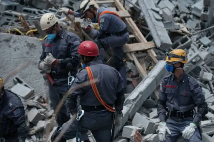 
	Bombeiros durante buscas em escombros de pr&eacute;dio que desabou em Guarulhos: de acordo com os Bombeiros, a retirada dos escombros est&aacute; sendo manual
 (Marcelo Camargo/ABr)