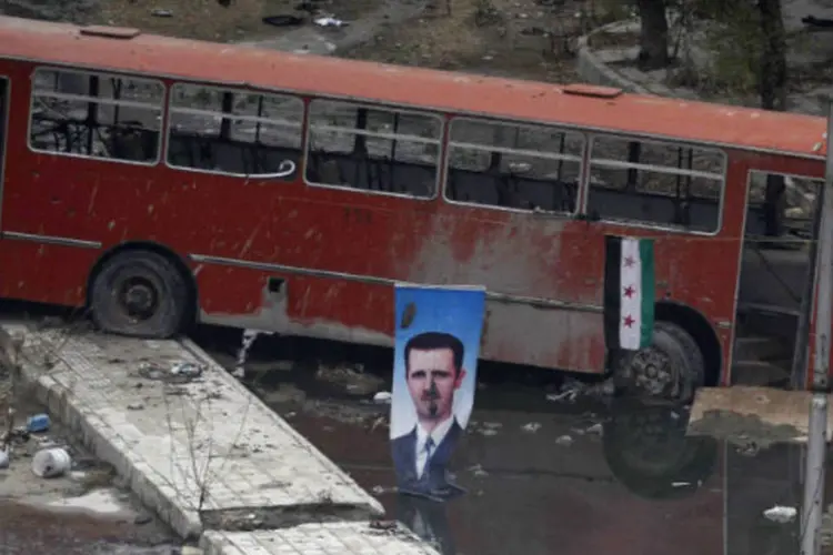 Foto do presidente sírio, Bashar al-Assad, em meio a destruição: regime e a oposição síria mantêm diferenças insolúveis (Molhem Barakat/Reuters)
