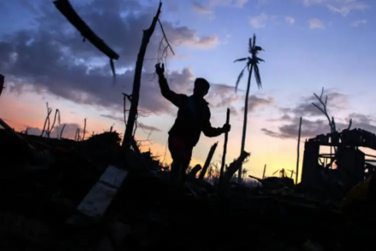 Homem caminha em meio a destruição nas Filipinas: ONG aponta que algumas localidades não tiveram nenhum tipo de assistência (Athit Perawongmetha/Reuters)