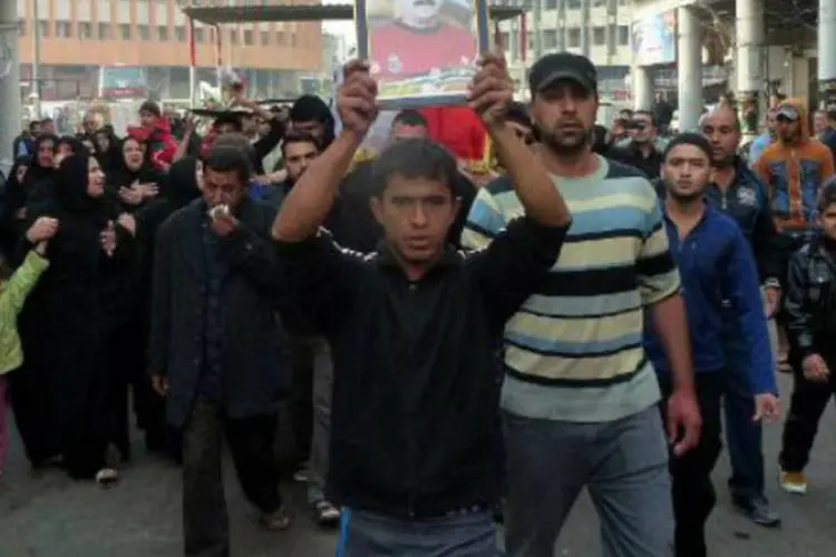 Iraquianos carregam o caixão e o retrato de uma vítima de ataque a bomba: no Iraque, condenados à pena capital geralmente são enforcados (Sabah Arar/AFP)