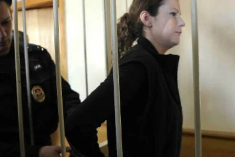 
	Policial russo algema a ativista brasileira do Greenpeace Ana Paula Maciel: ela foi a primeira a ser solta, ap&oacute;s a ONG pagar uma fian&ccedil;a de R$ 140 mil, mas ainda n&atilde;o pode sair do pa&iacute;s
 (Olga Maltseva/AFP)