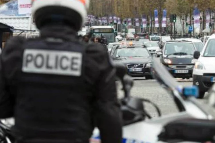 Policiais patrulham a avenida Champs-Elysees, em Paris: homem também é suspeito de ter atirado em um banco (Fred Dufour/AFP)