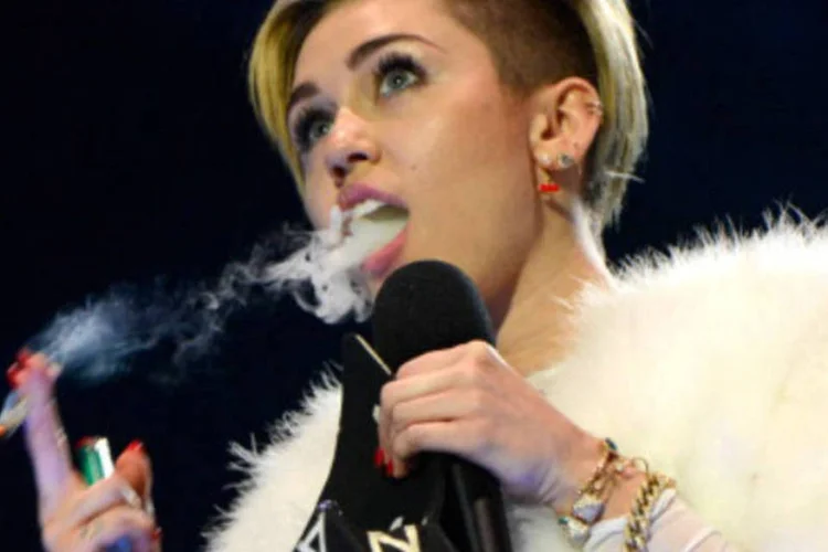 A cantora Miley Cyrus fuma o que parece ser um cigarro de maconha: "recebemos queixas sobre o tema", disse porta-voz de organização holandesa (Sven Hoogerhuis/AFP)