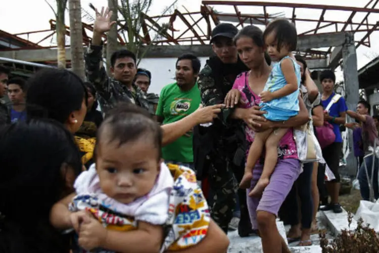 Equipes ajudam população afetada pelo tufão Haiyan, nas Filipinas:  tufão chegou à China com ventos de aproximadamente 118 km/h (Edgar Su/Reuters)