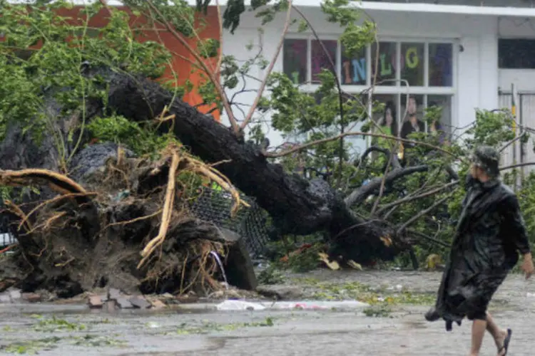 Pessoa passa por área destruída pelo tufão Haiyan, nas Filipinas: segundo o último balanço das autoridades, 700 mil pessoas foram afetadas no centro do país (Zander Casas/Reuters)
