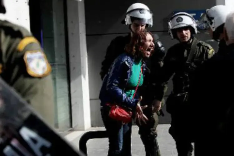 Mulher grita ao tentar passar por policiais gregos: policiais retiraram quase 200 pessoas que protestavam no local (Angelos Tzortzinis/AFP)