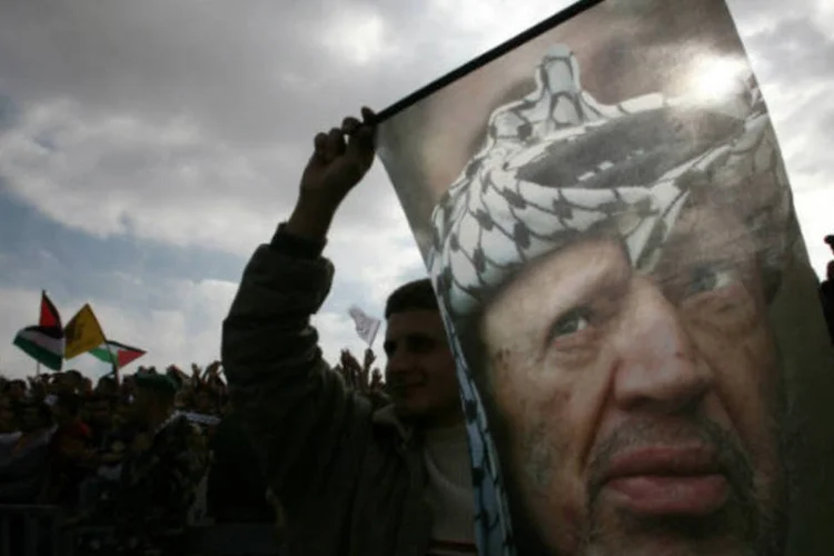 Palestino segura bandeira com Yasser Arafat: em 2004 o líder palestino "já estava marginalizado", segundo assessores (Oleg Popov/Files/Reuters)