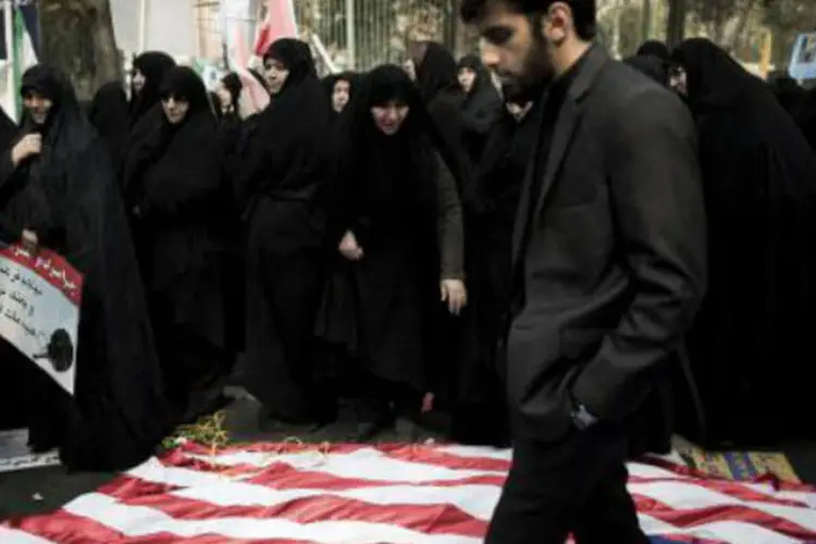 Iraniano pisa em uma bandeira dos Estados Unidos: mobilização foi maior que nos anos anteriores (Behrouz Mehri/AFP)