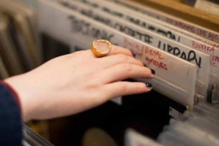 Consumidora escolhe um disco em loja de Londres: alguns são colecionadores, outros nunca se adaptaram ao som digital e outros buscam uma experiência nova (Leon Neal/AFP)