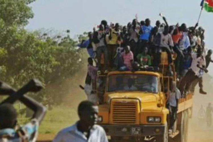 Moradores pendurados em um ônibus seguram uma bandeira do Sudão do Sul: referendo não foi reconhecido por nenhum dos dois Estados nem pela União Africana (AFP)