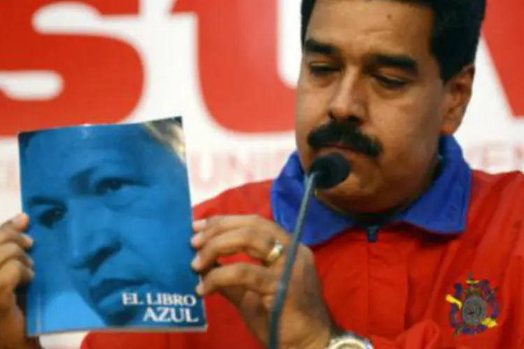 O presidente venezuelano, Nicolás Maduro, mostra um livro do ex-líder Hugo Chávez: "é o olhar da pátria que está em todos os lados", disse (Leo Ramirez/AFP)