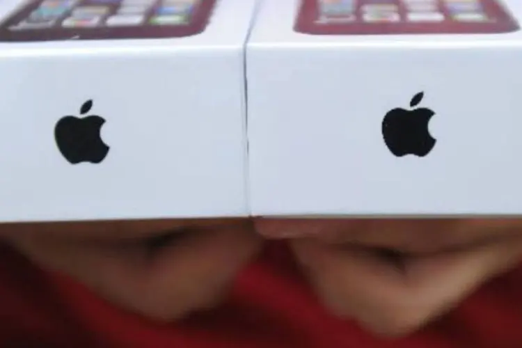 
	Homem exibe dois aparelhos iPhone 5S:&nbsp;companhia vendeu 33,8 milh&otilde;es de iPhones no trimestre, um recorde para o per&iacute;odo
 (Robyn Beck/AFP)
