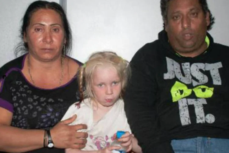 Christos Sali e sua esposa, Selini Sali, com a menina que criavam sem ser sua filha: casal tentou, em vão, registrar a criança como sua filha (AFP)