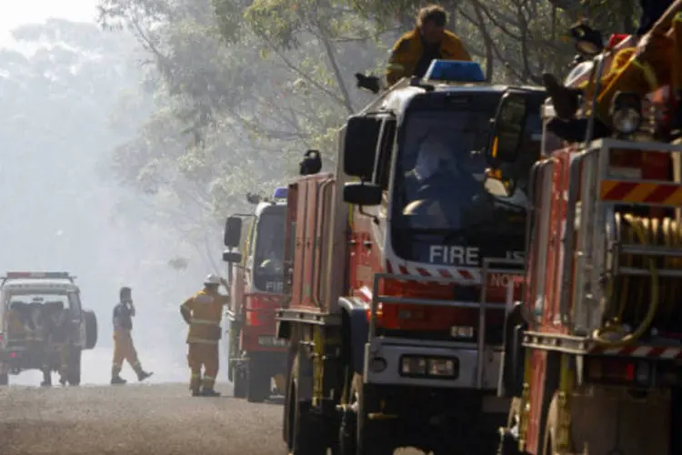 Bombeiros em região afetada por incêndio na Austrália: depois de oito dias ativo, incêndio já provocou a morte de duas pessoas (Rick Stevens/Reuters)