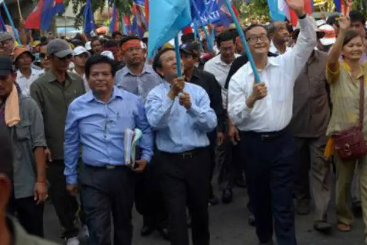 Chefe do Partido de Resgate do Camboja (CNRP), Sam Rainsy (c), marcha com manifestantes: cerca de 10.000 pessoas se reuniram (Tang Chhin Sothy/AFP)