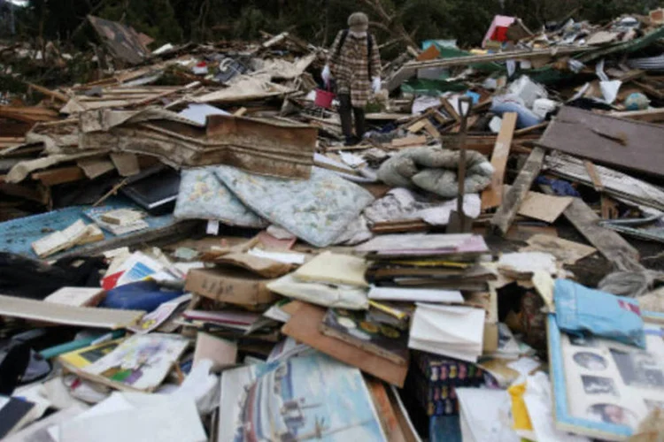 Sobrevivente em meio a destroços na ilha de Izu Oshima, devastada por tufão: chegada do tufão Francisco provocou a evacuação preventiva de parte da população (Yuya Shino/Reuters)