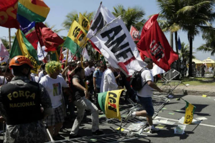 Manifestantes passam por bloqueio da Força Nacional, no Rio: grupo se aproxima do Windsor Barra Hotel, onde se realiza a primeira rodada de licitação do pré-sal (Ricardo Moraes/Reuters)