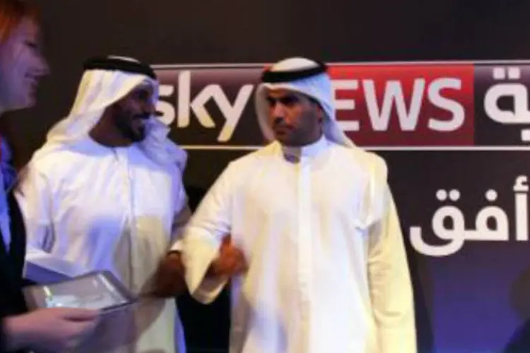 Pessoas passam em frente à logomarca da rede de televisão Sky News Arabia: rede explicou que havia perdido o contato desde a manhã de terça jornalista, cinegrafista e motorista (Marwan Naamani/AFP)
