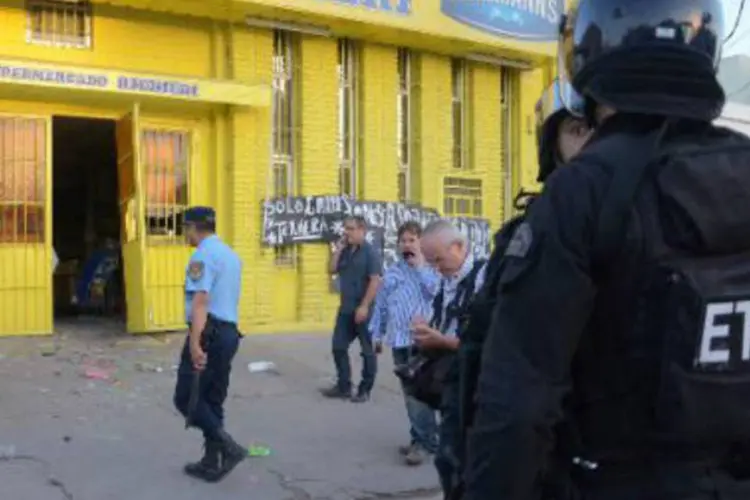 Policial vigia um supermercado saqueado em Córdoba: grupos de delinquentes assaltaram e depredaram lojas e supermercados (Irma Montiel/AFP)